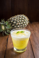 Glass of aloe vera juice on wooden background