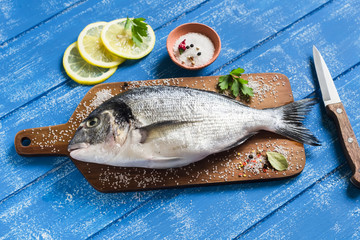 fresh Dorado fish and lemon on a blue wooden background