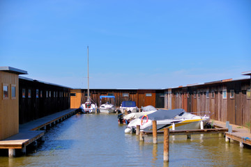 Fototapeta na wymiar Bootshäuser aus Holz mit Booten am Neusiedlersee in Rust