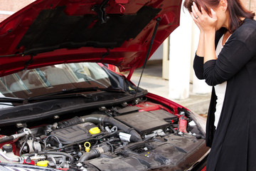 Frau weint wegen Motorschaden am Auto