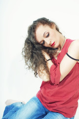 beautiful curly brunette woman in red T-shirt and blue jeans