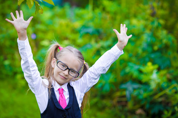 Fototapeta na wymiar Portrait of adorable little school girl in glasses outdoor