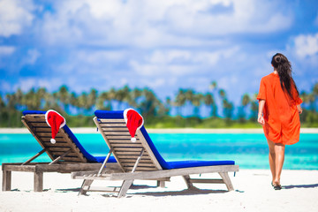 Fototapeta na wymiar Christmas concept: beach loungers with red Santa Hats and