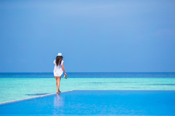 Beautiful young girl relaxing in outdoor swimming pool