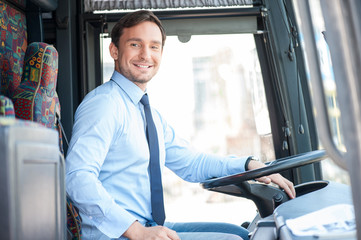 Attractive young man is driving a public transport