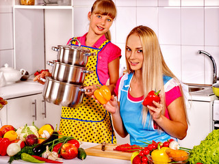 Mother and daughter cooking at kitchen.