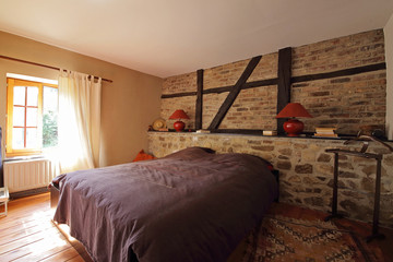 chambre en Ardennes avec mur de pierre et poutres apparentes