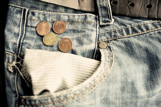 Old faded jeans with euro coins in empty pocket
