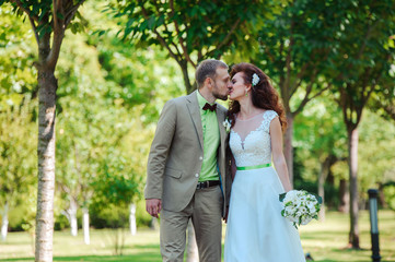 Bride and groom in green summer park