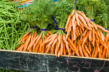 Orange fresh dug carrots at the market