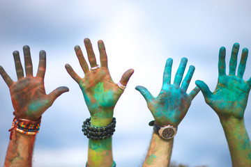 Painted hands against sky, two right and two left hands; holi festival celebration