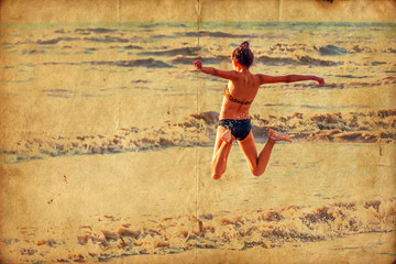 nostalgisch texturiertes Bild eines jungen Mädchens dass am Strand in die Luft springt