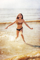 nostalgisch texturiertes Bild eines hübschen jungen Mädchens dass im Meer spielt