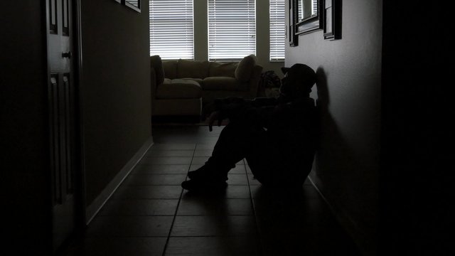 Lonely soldier silhouette sitting in dark hallway, WIDE, 4K