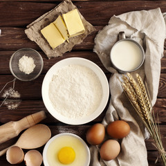 Fototapeta na wymiar On wooden table flour, egg, butter. Concept ingredients for bake