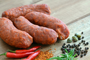 Chorizo - Rohwurst / Mit Gewürzen / Paprika (Chili), Pfeffer und Rosmarin auf Holztisch