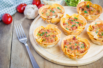 Homemade lasagna cups with minced meat, bolognese sauce topped with cheese