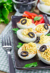 Spicy deviled eggs garnished with olives