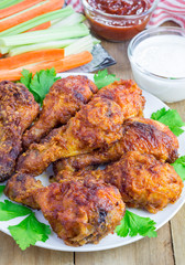 Roasted chicken served with celery and carrot sticks, blue cheese dressing and hot sauce