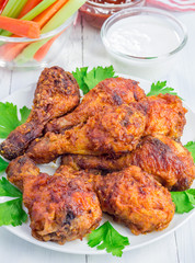 Roasted chicken served with celery and carrot sticks, blue cheese dressing and hot sauce