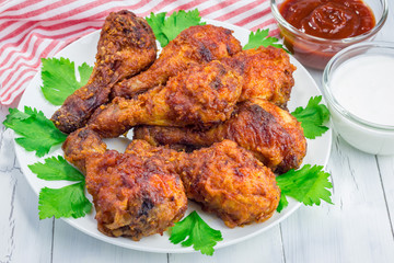 Roasted chicken served with celery and carrot sticks, blue cheese dressing and hot sauce
