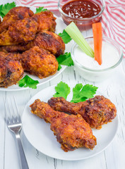 Roasted chicken served with celery and carrot sticks, blue cheese dressing and hot sauce