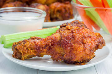 Roasted chicken served with celery and carrot sticks, blue cheese dressing and hot sauce