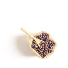Coffee beans and wooden spoon  on sack surface.Isolated on white