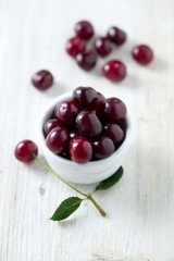 cherries in a bowl on wooden surface
