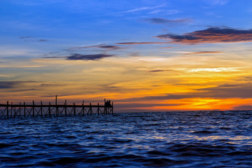 pier on the horizon of the sea at sunset