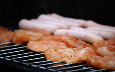 Delicious chicken meat and sausages on grill