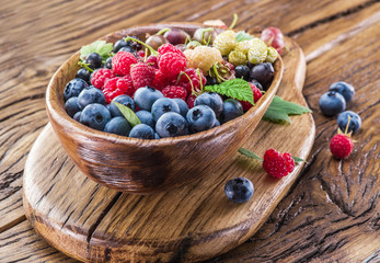 Ripe berries in the wooden bowl.