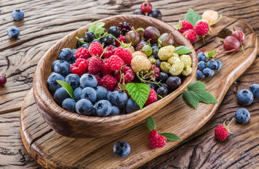 Ripe berries in the wooden bowl.