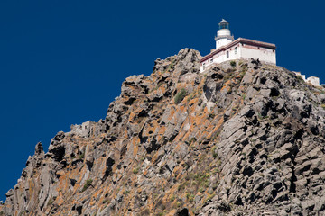 Ponza, faraglione e Faro della Guardia su cielo azzurro