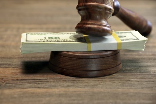 Bundle Of Money, Judges Gavel And Soundboard On Wooden Table