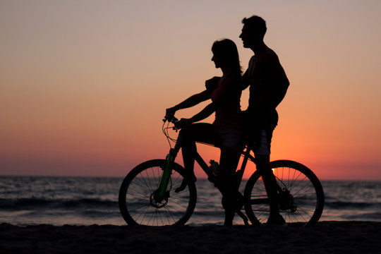 silhouette of couple bike at sunset