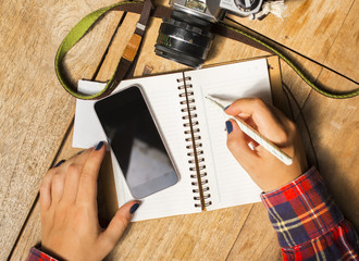 girl with blank cell phone, diary and old camera