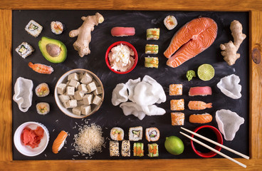Sushi and ingredients on dark background