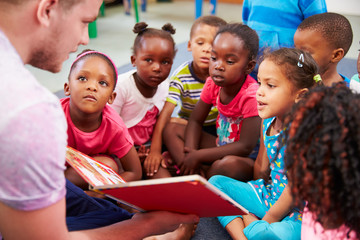 Fototapeta na wymiar Volunteer teacher reading to a class of preschool kids