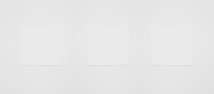 Blank pictures frames on white wall