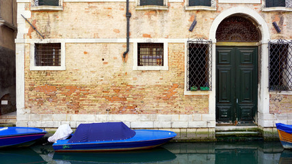 Fototapeta na wymiar canal and boats with ancient brick wall house