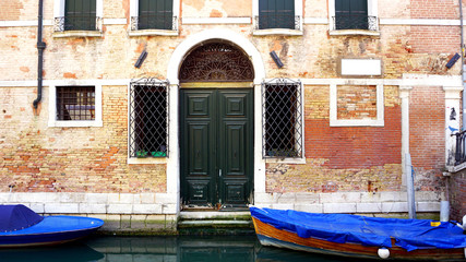 Fototapeta na wymiar canal and boats with ancient brick wall