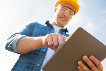 close up of builder in hardhat with tablet pc