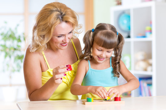 kid with mother playing together at table