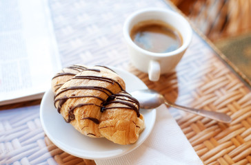 Cup of coffee and a croissant on the table