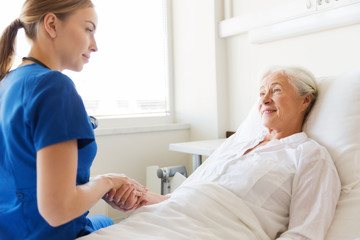 doctor or nurse visiting senior woman at hospital
