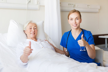 Fototapeta premium nurse and senior woman showing thumbs up at clinic