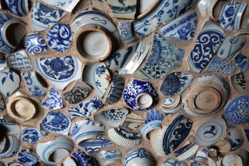 Part of a wall decorated with broken blue and white pottery