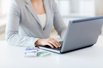close up of woman hands with laptop and money