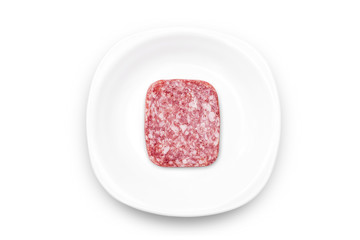 Square slice of salami isolated on white